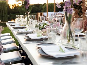 Sfeervol gedekte lange dinertafel aan het water bij Dekker Zoetermeer, met elegante bloemen, wijnglazen en romantische decoratie. Ideaal voor een bruiloft, feest of bijzonder diner.