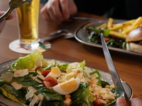 Gasten genieten van een heerlijke lunch bij Dekker Zoetermeer, met een frisse salade met ei, tomaat en Parmezaanse kaas, een broodje met friet en een verfrissend drankje.