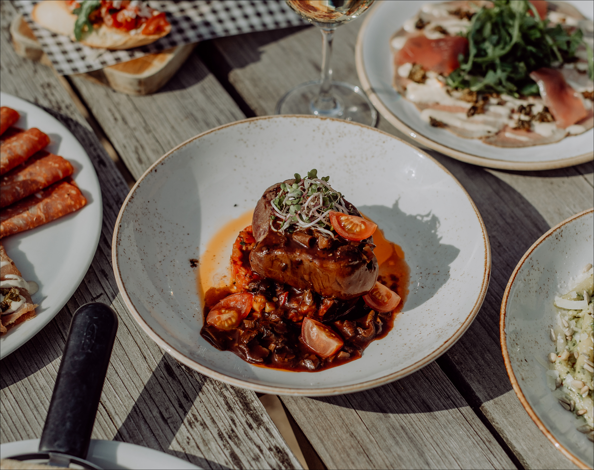 Smaakvol bereid vleesgerecht met rijke saus, cherrytomaatjes en verse kruiden, geserveerd bij restaurant Sweet Lake Italy in Dekker Zoetermeer.